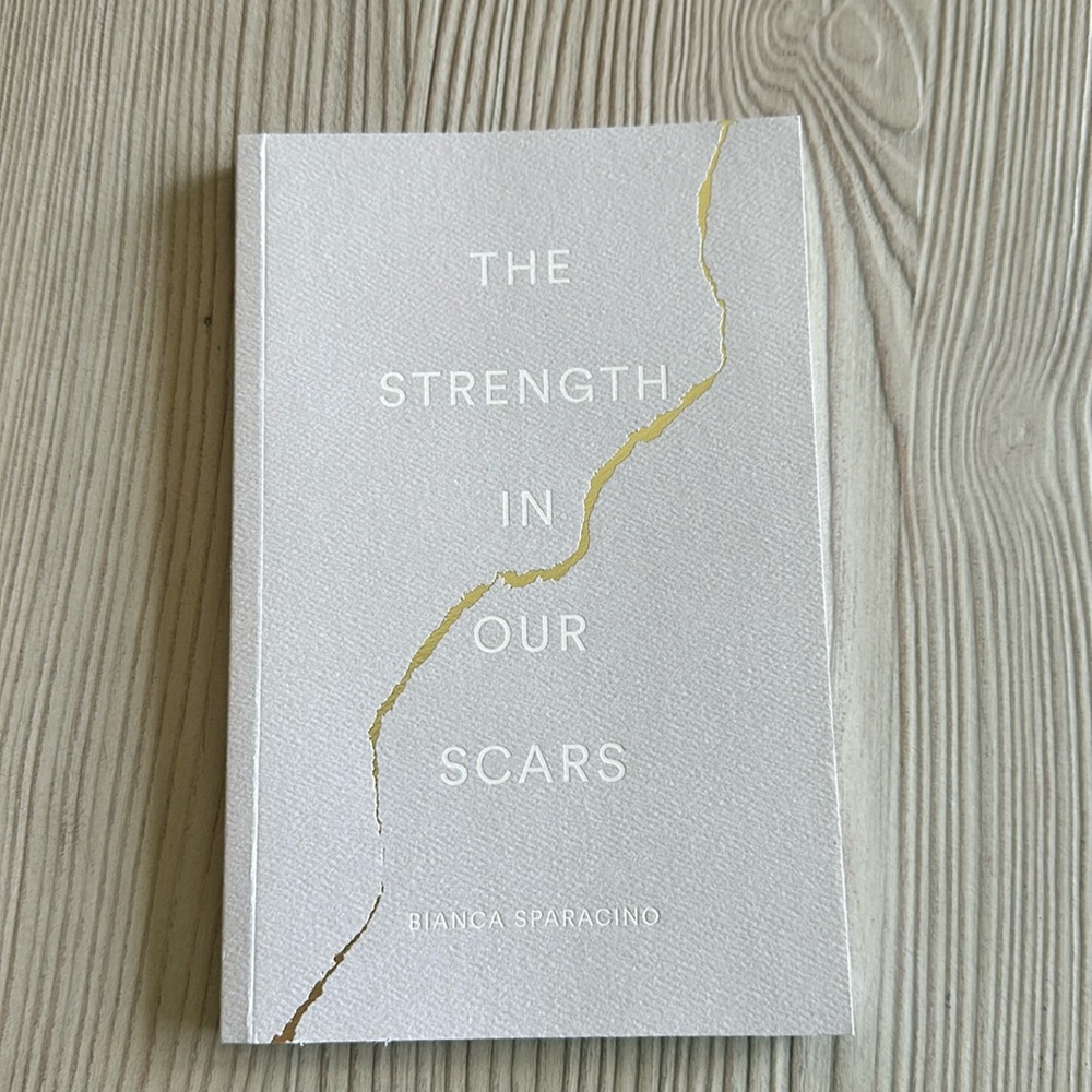 Soft cover copy of “The Strength in our scars” by Bianca Sparacino